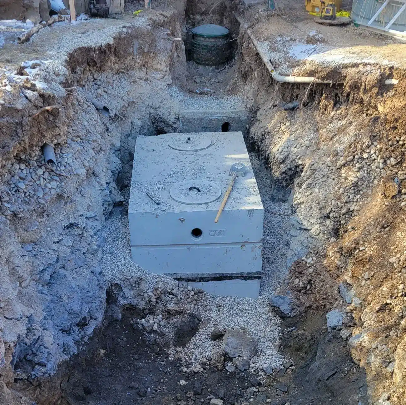 New concrete septic tank being set in an excavated hole near Boise, Idaho