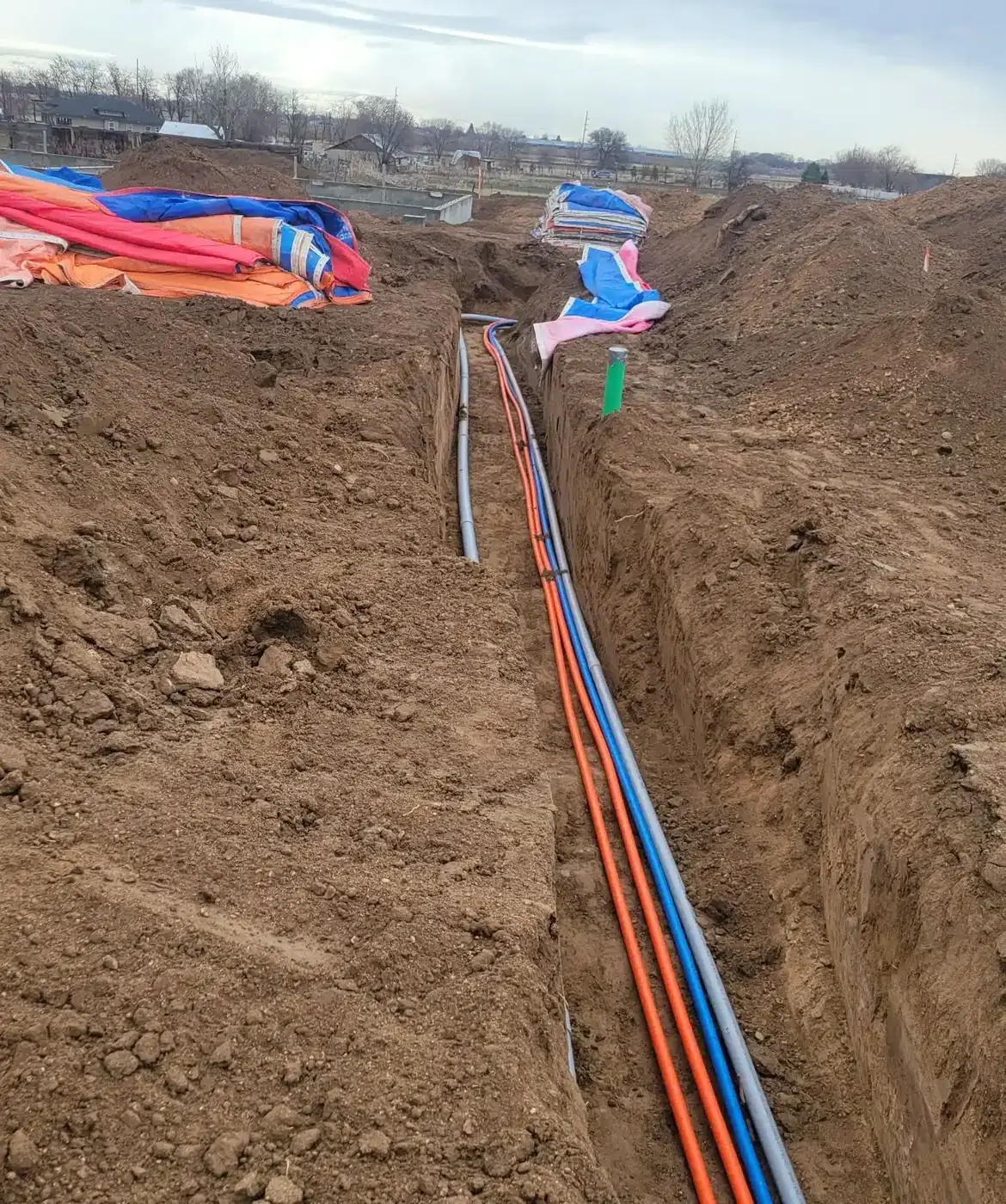 Crew placing pipe in an excavated utility trench in Idaho