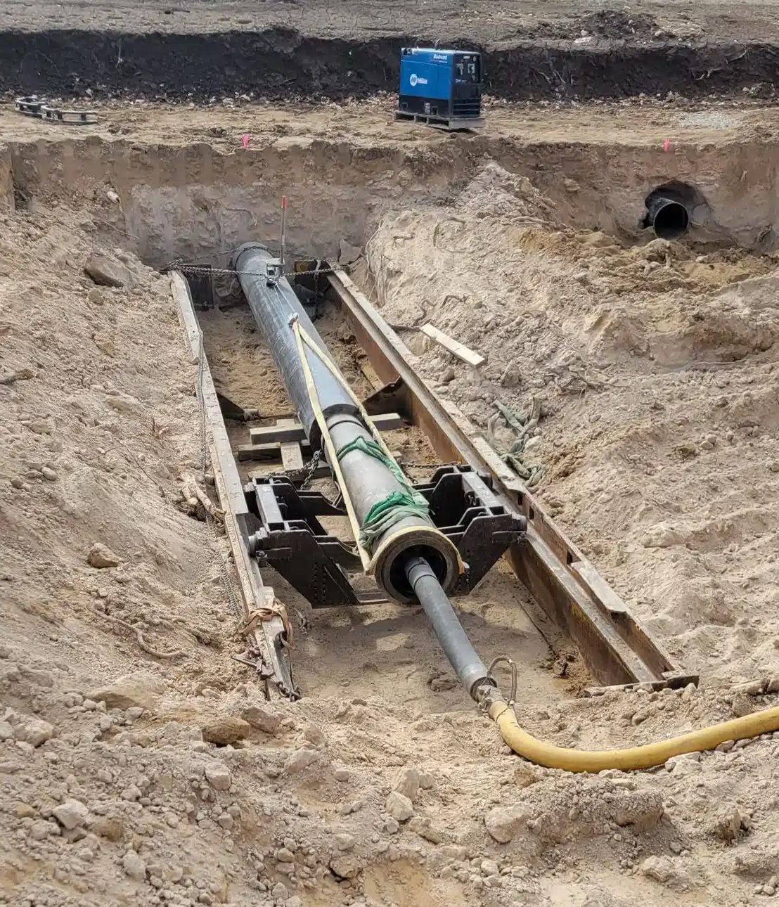 Shamrock crew member connecting a new water line in an open trench