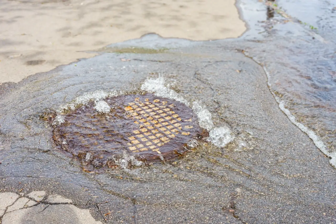 Water pouring out of a sewer hatch during an underground line failure